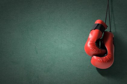 Red boxing gloves hanging on wall