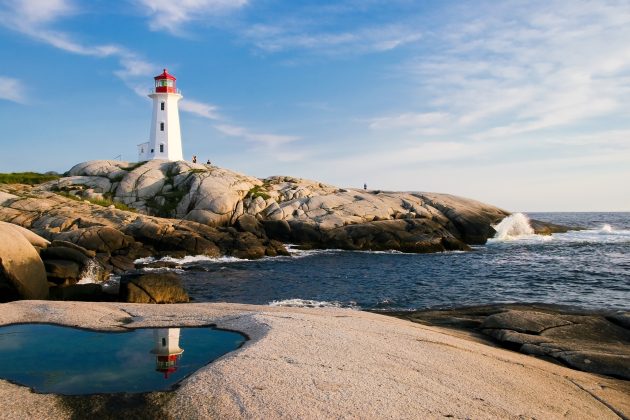 Lighthouse on crest of hill next to the ocean