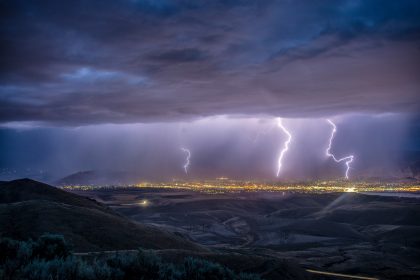 Lightning striking a distant city in a valley