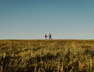 Couple holding hands in field