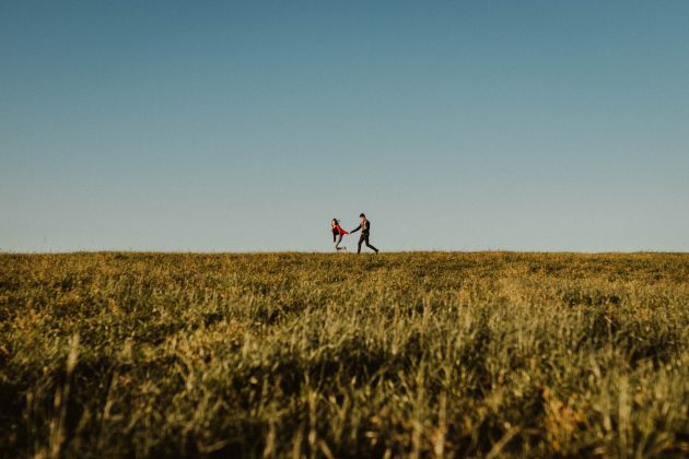 Couple holding hands in field