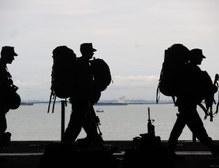Silhouette of Military Personnel Walking On Ship