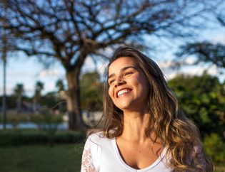 Woman in white smiling outside