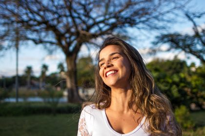 Woman in white smiling outside