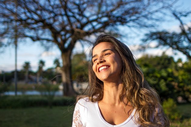 Woman in white smiling outside