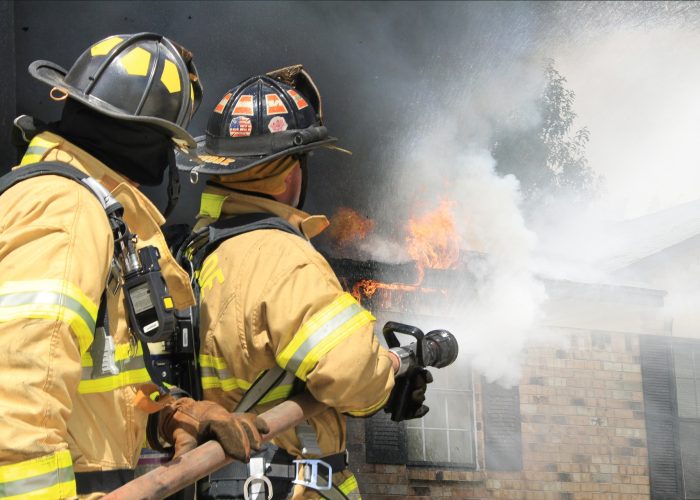 Fire fighters extinguishing house fire