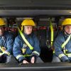 Firefighters in gear sitting inside a fire truck